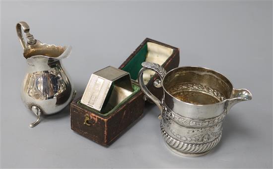 A Scottish Victorian silver cream jug, another silver cream jug and a cased napkin ring,